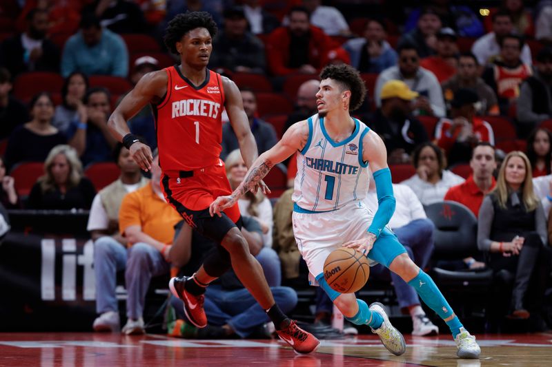 HOUSTON, TEXAS - NOVEMBER 01: LaMelo Ball #1 of the Charlotte Hornets controls the ball ahead of Amen Thompson #1 of the Houston Rockets during the first half at Toyota Center on November 01, 2023 in Houston, Texas. (Photo by Carmen Mandato/Getty Images)