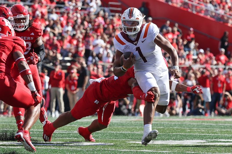 Sep 16, 2023; Piscataway, New Jersey, USA; Virginia Tech Hokies quarterback Kyron Drones (1) is tackled by Rutgers Scarlet Knights linebacker Tyreem Powell (22) during the first half at SHI Stadium. Mandatory Credit: Vincent Carchietta-USA TODAY Sports