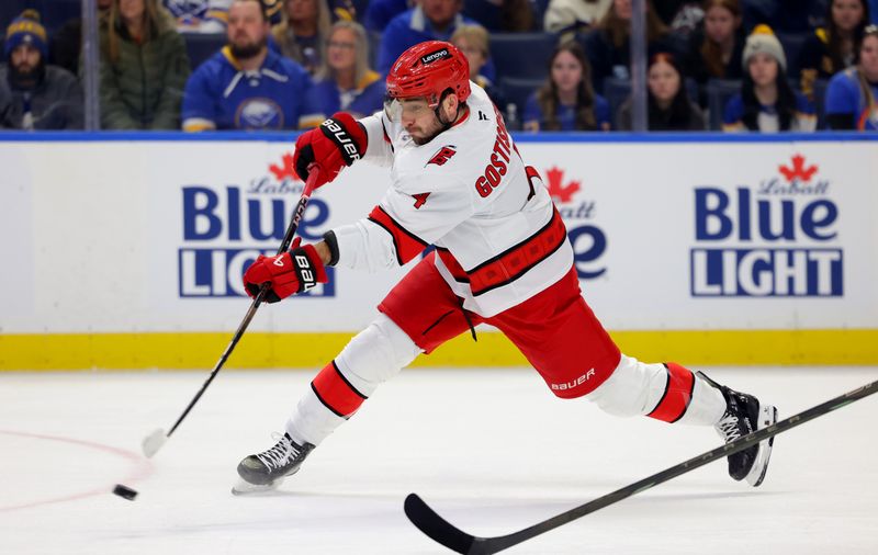 Jan 15, 2025; Buffalo, New York, USA;  Carolina Hurricanes defenseman Shayne Gostisbehere (4) takes a shot on goal during the first period against the Buffalo Sabres at KeyBank Center. Mandatory Credit: Timothy T. Ludwig-Imagn Images