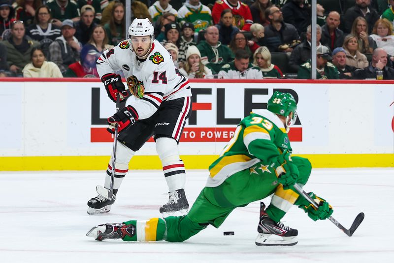 Dec 3, 2023; Saint Paul, Minnesota, USA; Chicago Blackhawks left wing Boris Katchouk (14) passes against Minnesota Wild defenseman Alex Goligoski (33) during the third period at Xcel Energy Center. Mandatory Credit: Matt Krohn-USA TODAY Sports