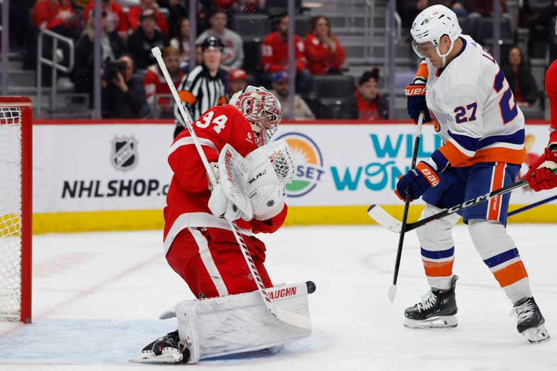 Feb 29, 2024; Detroit, Michigan, USA;  Detroit Red Wings goaltender Alex Lyon (34) makes a save on New York Islanders left wing Anders Lee (27) in the first period at Little Caesars Arena. Mandatory Credit: Rick Osentoski-USA TODAY Sports