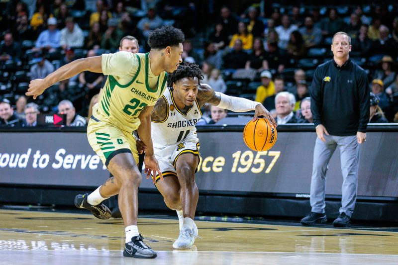 Jan 14, 2025; Wichita, Kansas, USA; Wichita State Shockers guard Justin Hill (11) drives around Charlotte 49ers guard Jaehshon Thomas (22) during the second half at Charles Koch Arena. Mandatory Credit: William Purnell-Imagn Images