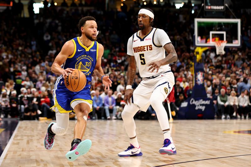 DENVER, COLORADO - DECEMBER 25: Stephen Curry #30 of the Golden State Warriors drives past Kentavious Caldwell-Pope #5 of the Denver Nuggets at Ball Arena on December 25, 2023 in Denver, Colorado. NOTE TO USER: User expressly acknowledges and agrees that, by downloading and/or using this Photograph, user is consenting to the terms and conditions of the Getty Images License Agreement. (Photo by Jamie Schwaberow/Getty Images)