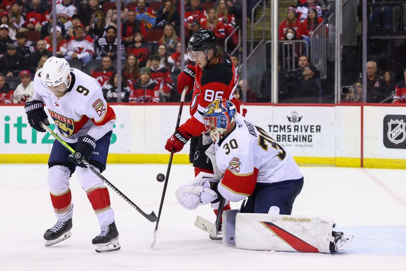 Jan 14, 2025; Newark, New Jersey, USA; New Jersey Devils center Jack Hughes (86) tries to tip the puck in front of Florida Panthers goaltender Spencer Knight (30) during overtime at Prudential Center. Mandatory Credit: Ed Mulholland-Imagn Images