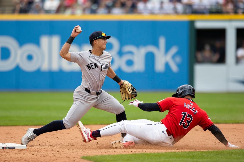 Apr 14, 2024; Cleveland, Ohio, USA; New York Yankees shortstop Anthony Volpe (11) tags second base to force out Cleveland Guardians shortstop Gabriel Arias (13) during the ninth inning at Progressive Field. Mandatory Credit: Scott Galvin-USA TODAY Sports