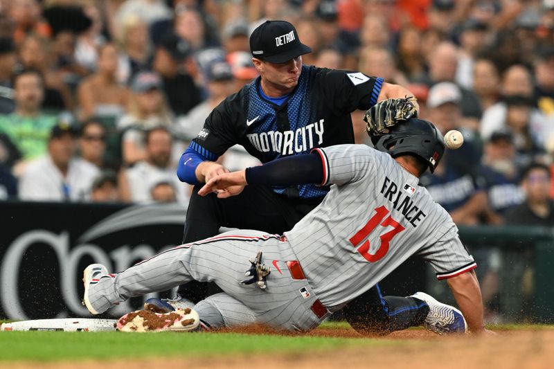 Jun 27, 2025; Detroit, Michigan, USA; Minnesota Twins first base Ty France (13) slides safely into third base as the throw to Detroit Tigers third baseman Colt Keith (33) hits France in the head in the sixth inning at Comerica Park. Mandatory Credit: Lon Horwedel-Imagn Images