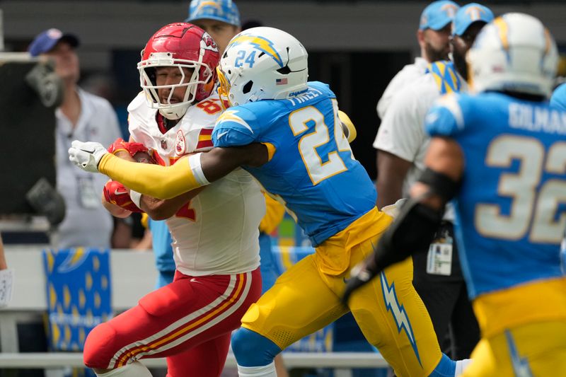 Kansas City Chiefs tight end Travis Kelce, left, is stopped by Los Angeles Chargers safety AJ Finley (24) after catching a pass for a 38-yard gain during the first half of an NFL football game Sunday, Sept. 29, 2024, in Inglewood, Calif. (AP Photo/Ashley Landis)