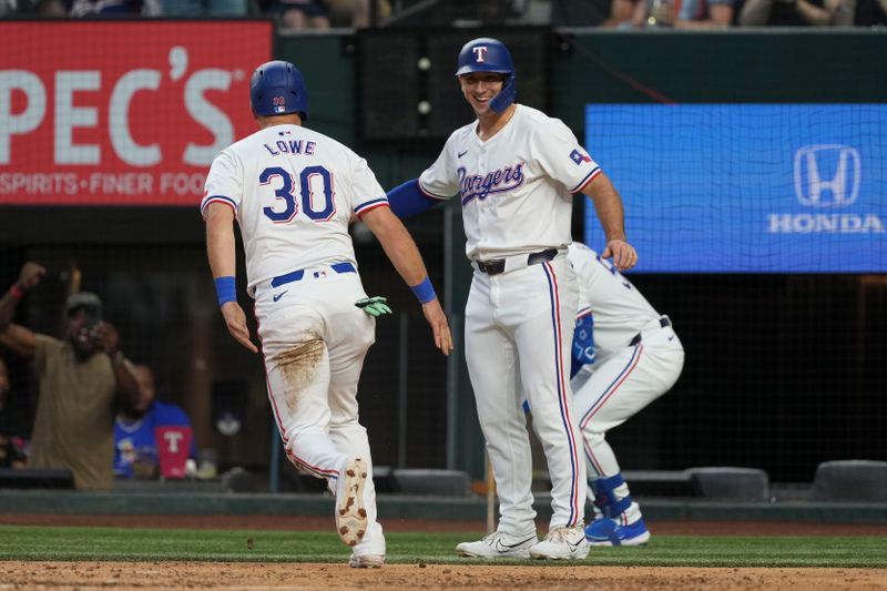 Sep 7, 2024; Arlington, Texas, USA; Texas Rangers first baseman Nathaniel Lowe (30) and center fielder Wyatt Langford (36) celebrate scoring on a double hit by left fielder Ezequiel Duran (not shown) during the fifth inning against the Los Angeles Angels at Globe Life Field. Mandatory Credit: Jim Cowsert-Imagn Images