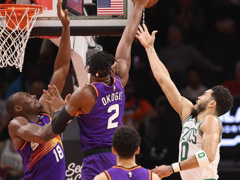 PHOENIX, ARIZONA - DECEMBER 07: Jayson Tatum #0 of the Boston Celtics lays up a shot past Josh Okogie #2 and Bismack Biyombo #18 of the Phoenix Suns during the second half of the NBA game at Footprint Center on December 07, 2022 in Phoenix, Arizona. NOTE TO USER: User expressly acknowledges and agrees that, by downloading and or using this photograph, User is consenting to the terms and conditions of the Getty Images License Agreement. (Photo by Christian Petersen/Getty Images)