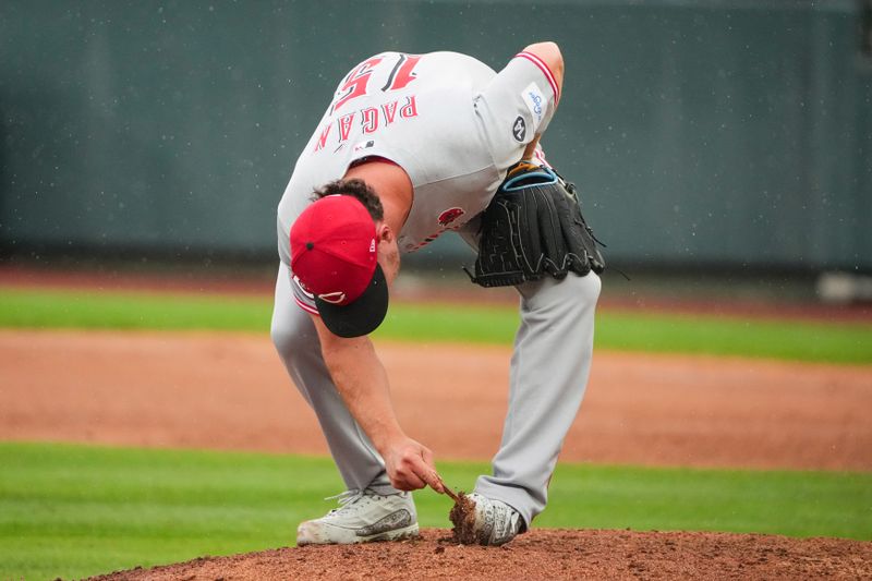 May 26, 2025; Kansas City, Missouri, USA; Cincinnati Reds pitcher Emilio Pagán (15) cleans the dirt from his cleats on the mound against the Kansas City Royals in the ninth inning at Kauffman Stadium. Mandatory Credit: Denny Medley-Imagn Images