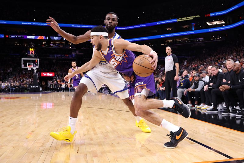 PHOENIX, ARIZONA - NOVEMBER 30: Devin Booker #1 of the Phoenix Suns drives past Andrew Wiggins #22 of the Golden State Warriors during the first half at Footprint Center on November 30, 2024 in Phoenix, Arizona. NOTE TO USER: User expressly acknowledges and agrees that, by downloading and or using this photograph, User is consenting to the terms and conditions of the Getty Images License Agreement.  (Photo by Chris Coduto/Getty Images)