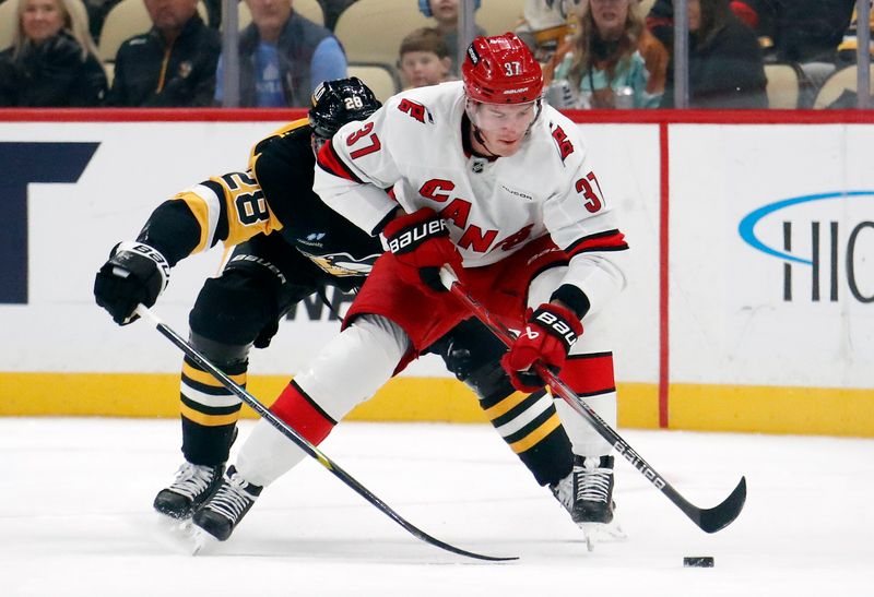 Oct 18, 2024; Pittsburgh, Pennsylvania, USA;  Carolina Hurricanes right wing Andrei Svechnikov (37) handles the puck ahead of Pittsburgh Penguins defenseman Marcus Pettersson (28) during the first period at PPG Paints Arena. Mandatory Credit: Charles LeClaire-Imagn Images