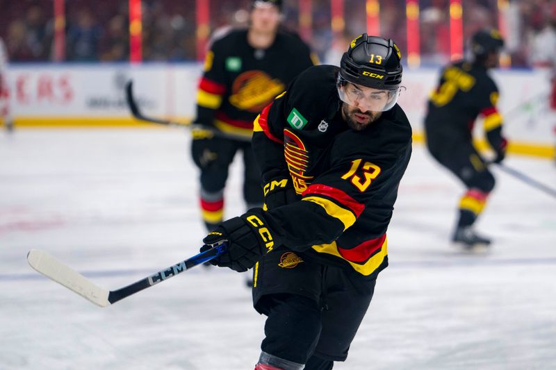 Oct 28, 2024; Vancouver, British Columbia, CAN; Vancouver Canucks forward Arshdeep Bains (13) shoots during warm up prior to a game against the Carolina Hurricanes at Rogers Arena. Mandatory Credit: Bob Frid-Imagn Images