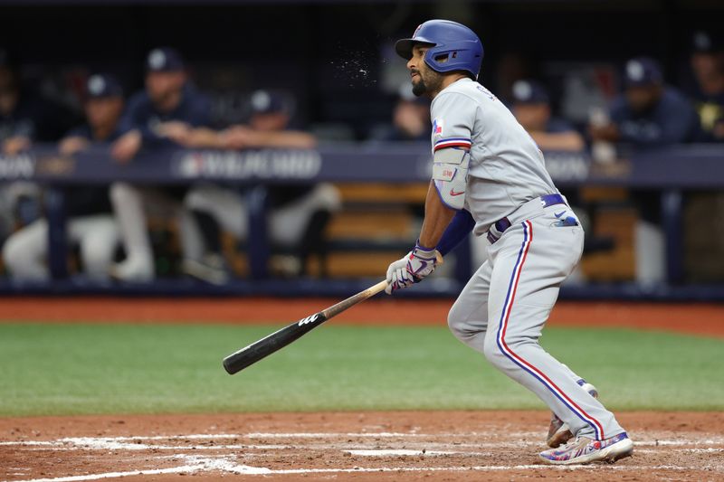 Oct 4, 2023; St. Petersburg, Florida, USA; Texas Rangers second baseman Marcus Semien (2) hits an RBI double against the Tampa Bay Rays in the sixth inning during game two of the Wildcard series for the 2023 MLB playoffs at Tropicana Field. Mandatory Credit: Nathan Ray Seebeck-USA TODAY Sports