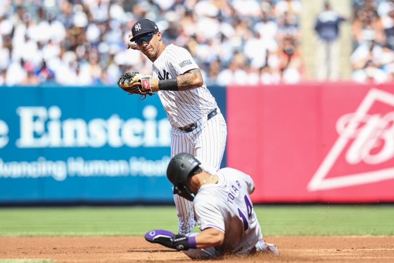 Aug 25, 2024; Bronx, New York, USA;  New York Yankees second base Gleyber Torres (25) throws past Colorado Rockies shortstop Ezequiel Tovar (14) attempting to complete a double play in the first inning at Yankee Stadium. Mandatory Credit: Wendell Cruz-USA TODAY Sports