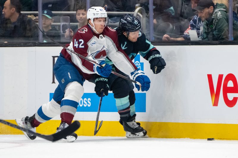 Oct 22, 2024; Seattle, Washington, USA;  Colorado Avalanche defenseman Josh Manson (42) checks Seattle Kraken forward Brandon Tanev (13) during the first period at Climate Pledge Arena. Mandatory Credit: Stephen Brashear-Imagn Images