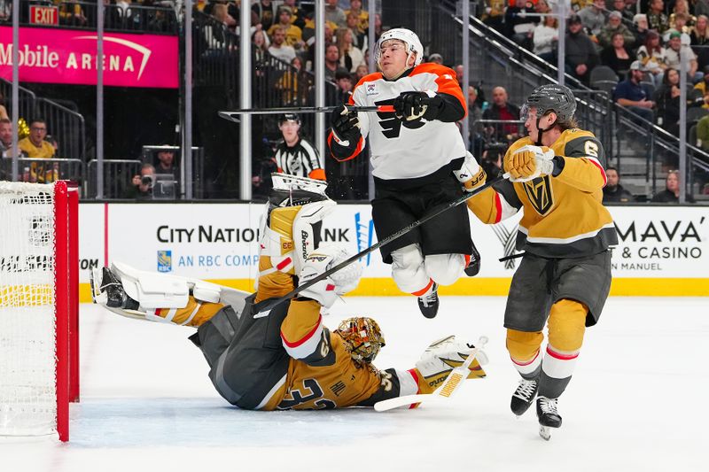 Jan 19, 2026; Las Vegas, Nevada, USA; Philadelphia Flyers right wing Bobby Brink (10) is upended as Vegas Golden Knights goaltender Adin Hill (33) makes the save behind defenseman Kaedan Korczak (6) during the second period at T-Mobile Arena. Mandatory Credit: Stephen R. Sylvanie-Imagn Images