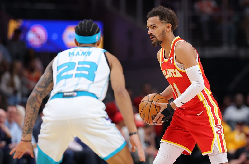 ATLANTA, GEORGIA - APRIL 10:  Trae Young #11 of the Atlanta Hawks runs the offense against Tre Mann #23 of the Charlotte Hornets during the first quarter at State Farm Arena on April 10, 2024 in Atlanta, Georgia.  NOTE TO USER: User expressly acknowledges and agrees that, by downloading and/or using this photograph, user is consenting to the terms and conditions of the Getty Images License Agreement.  (Photo by Kevin C. Cox/Getty Images)