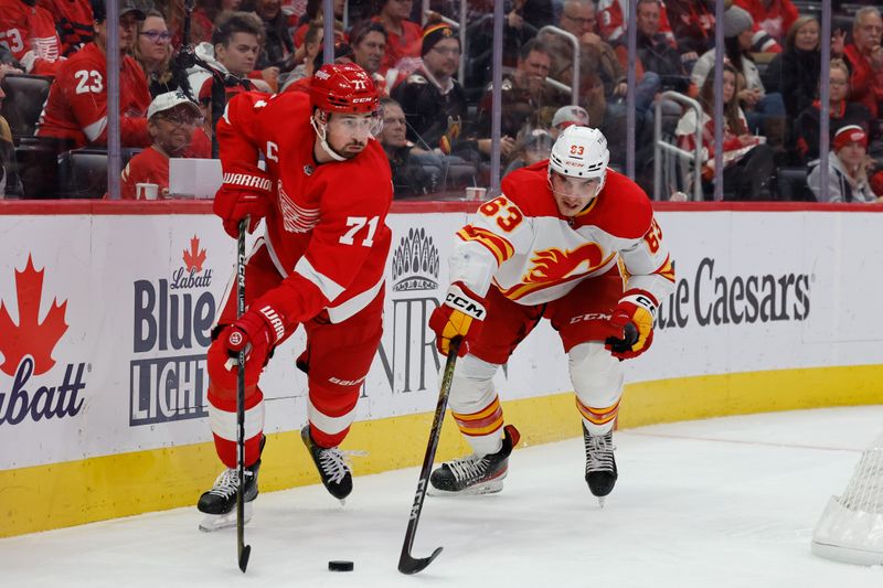 Oct 22, 2023; Detroit, Michigan, USA;  Detroit Red Wings center Dylan Larkin (71) and Calgary Flames center Adam Ruzicka (63) battle for the puck in the third period at Little Caesars Arena. Mandatory Credit: Rick Osentoski-USA TODAY Sports