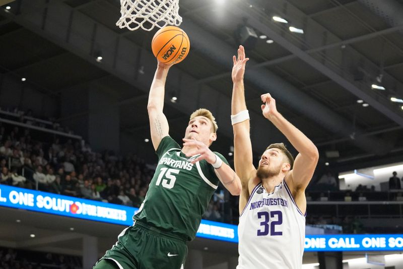 Jan 7, 2024; Evanston, Illinois, USA; Michigan State Spartans center Carson Cooper (15) goes up for a dunk on Northwestern Wildcats forward Blake Preston (32) during the first half at Welsh-Ryan Arena. Mandatory Credit: David Banks-USA TODAY Sports