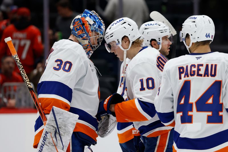 Oct 31, 2025; Washington, District of Columbia, USA; New York Islanders goaltender Ilya Sorokin (30) celebrates with Islanders right wing Simon Holmstrom (10) after their game Washington Capitals at Capital One Arena. Mandatory Credit: Geoff Burke-Imagn Images