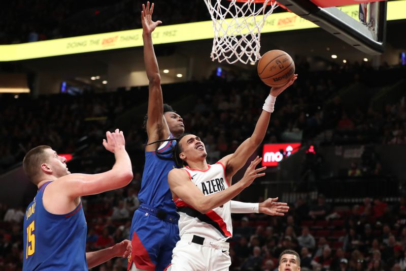 PORTLAND, OREGON - FEBRUARY 23: Dalano Banton #5 of the Portland Trail Blazers drives to the basket as Peyton Watson #8 of the Denver Nuggets defends during the first quarter at Moda Center on February 23, 2024 in Portland, Oregon. NOTE TO USER: User expressly acknowledges and agrees that, by downloading and or using this photograph, User is consenting to the terms and conditions of the Getty Images License Agreement.? (Photo by Amanda Loman/Getty Images)