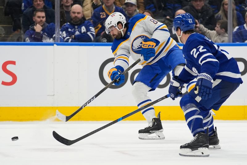 Jan 27, 2026; Toronto, Ontario, CAN; Buffalo Sabres forward Alex Tuch (89) shoots the puck as Toronto Maple Leafs defenseman Jake McCabe (22) closes in during the second period at Scotiabank Arena. Mandatory Credit: John E. Sokolowski-Imagn Images