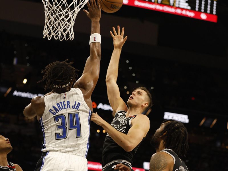 SAN ANTONIO, TX - MARCH 14:  Zach Collins #23 of the San Antonio Spurs shoots over Wendell Carter Jr.#34 of the Orlando Magic in the first half at AT&T Center on March 14, 2023 in San Antonio, Texas. NOTE TO USER: User expressly acknowledges and agrees that, by downloading and or using this photograph, User is consenting to terms and conditions of the Getty Images License Agreement. (Photo by Ronald Cortes/Getty Images)