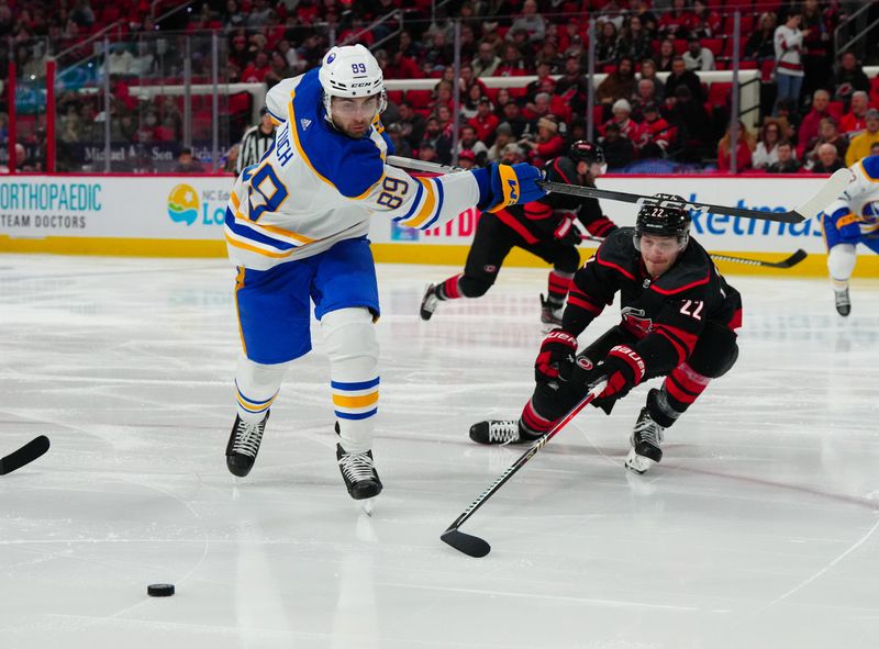 Dec 2, 2023; Raleigh, North Carolina, USA; Carolina Hurricanes defenseman Brett Pesce (22) blocks the shot attempt by Buffalo Sabres right wing Alex Tuch (89) during the second period at PNC Arena. Mandatory Credit: James Guillory-USA TODAY Sports