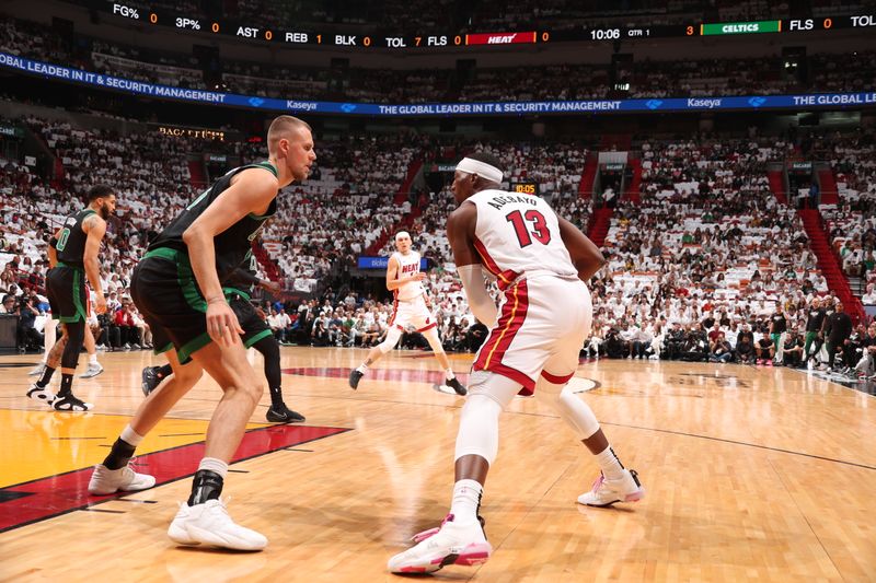 MIAMI, FL - APRIL 27: Bam Adebayo #13 of the Miami Heat handles the ball against Kristaps Porzingis #8 of the Boston Celtics during the game during Round 1 Game 3 of the 2024 NBA Playoffs on April 27, 2024 at Kaseya Center in Miami, Florida. NOTE TO USER: User expressly acknowledges and agrees that, by downloading and or using this Photograph, user is consenting to the terms and conditions of the Getty Images License Agreement. Mandatory Copyright Notice: Copyright 2024 NBAE (Photo by Issac Baldizon/NBAE via Getty Images)