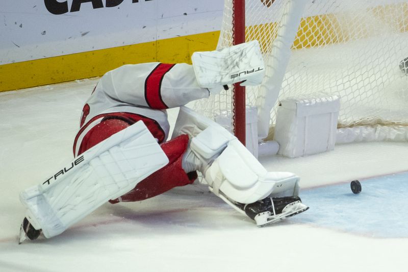 Dec 12, 2023; Ottawa, Ontario, CAN; Carolina Hurricanes goalie Pyotr  Kochetkov (52) tries to get to a rolling puck in the third period against the Ottawa Senators at the Canadian Tire Centre. Mandatory Credit: Marc DesRosiers-USA TODAY Sports.