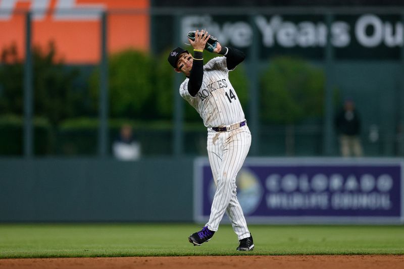 May 10, 2024; Denver, Colorado, USA; Colorado Rockies shortstop Ezequiel Tovar (14) makes a catch for an out in the ninth inning against the Texas Rangers at Coors Field. Mandatory Credit: Isaiah J. Downing-USA TODAY Sports