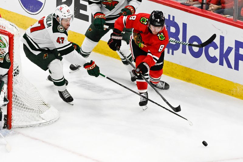 Apr 7, 2024; Chicago, Illinois, USA;  Minnesota Wild defenseman Declan Chisholm (47) and Chicago Blackhawks center Ryan Donato (8) chase the puck during the second period at United Center. Mandatory Credit: Matt Marton-USA TODAY Sports