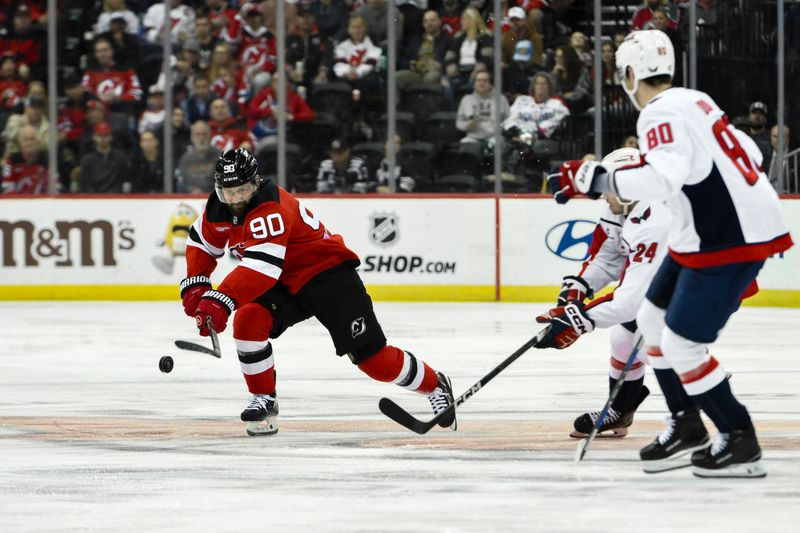 Oct 19, 2024; Newark, New Jersey, USA; New Jersey Devils left wing Tomas Tatar (90) controls the puck as Washington Capitals center Connor McMichael (24) and Washington Capitals left wing Pierre-Luc Dubois (80) defend during the second period at Prudential Center. Mandatory Credit: John Jones-Imagn Images