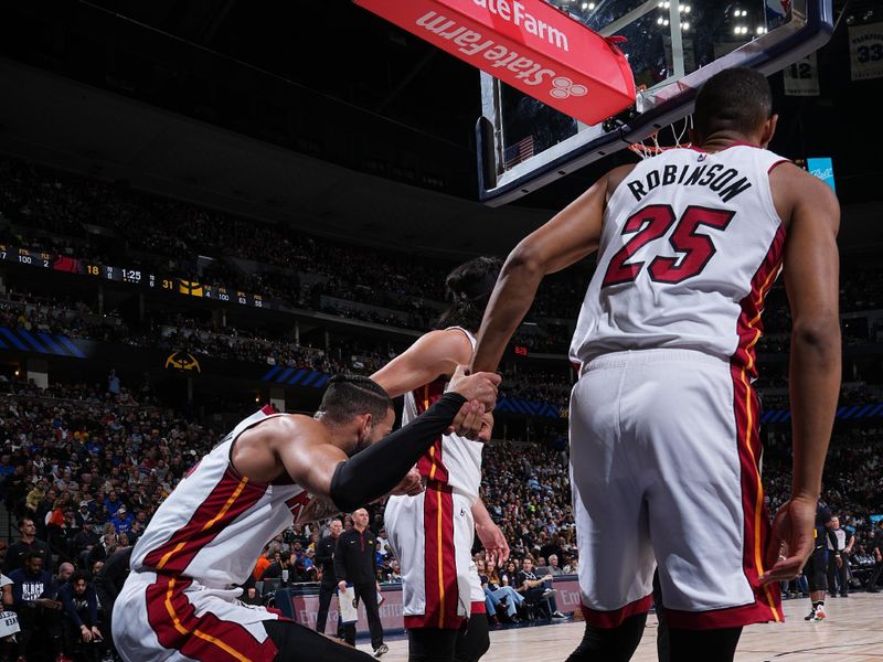 DENVER, CO - FEBRUARY 29: Caleb Martin #16 of the Miami Heat is helped up by Jaime Jaquez Jr. #11 and Orlando Robinson #25 during the game against the Denver Nuggets on February 29, 2024 at the Ball Arena in Denver, Colorado. NOTE TO USER: User expressly acknowledges and agrees that, by downloading and/or using this Photograph, user is consenting to the terms and conditions of the Getty Images License Agreement. Mandatory Copyright Notice: Copyright 2024 NBAE (Photo by Garrett Ellwood/NBAE via Getty Images)