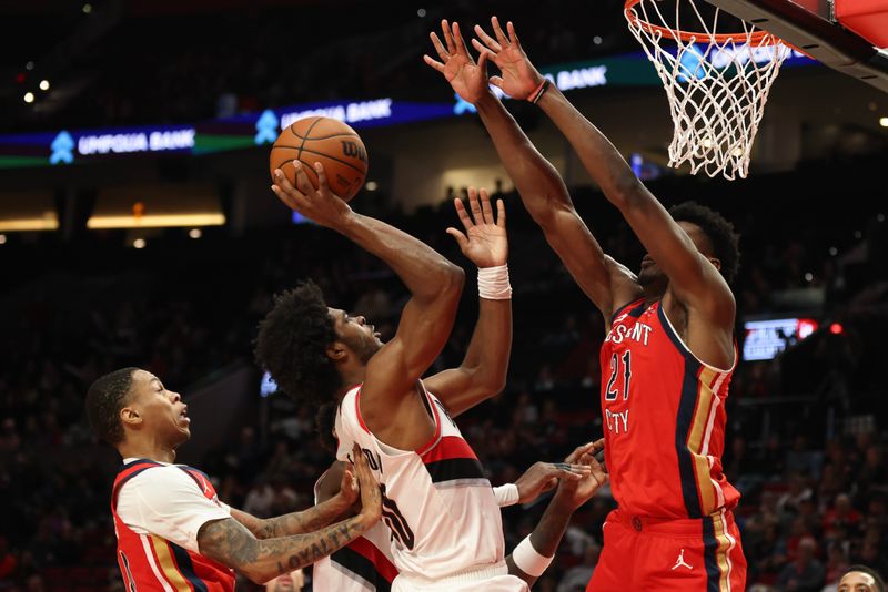 PORTLAND, OREGON - OCTOBER 27: Scoot Henderson #00 of the Portland Trail Blazers shoots from between Jordan Hawkins #24, left, and Yves Missi #21 of the New Orleans Pelicans during the fourth quarter at Moda Center on October 27, 2024 in Portland, Oregon. NOTE TO USER: User expressly acknowledges and agrees that, by downloading and or using this photograph, User is consenting to the terms and conditions of the Getty Images License Agreement.? (Photo by Amanda Loman/Getty Images)