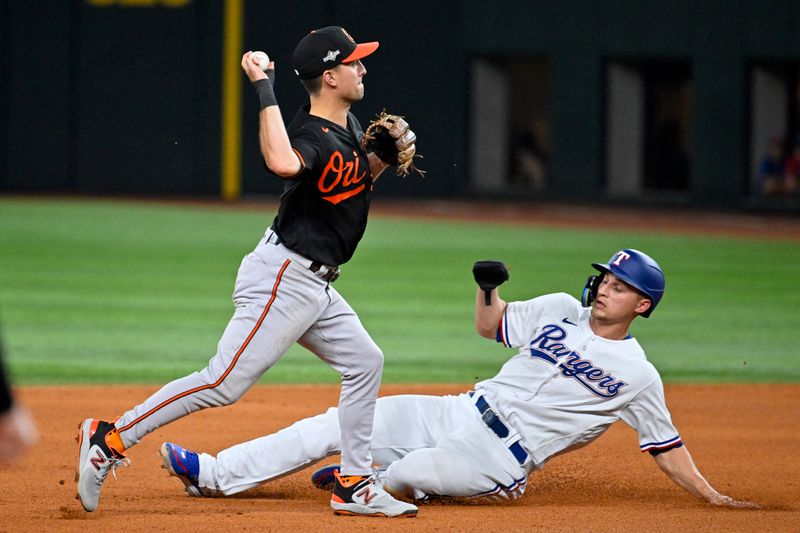 Oct 10, 2023; Arlington, Texas, USA; Texas Rangers shortstop Corey Seager (5) is out at second against Baltimore Orioles second baseman Adam Frazier (12) on a double play in the fourth inning during game three of the ALDS for the 2023 MLB playoffs at Globe Life Field. Mandatory Credit: Jerome Miron-USA TODAY Sports