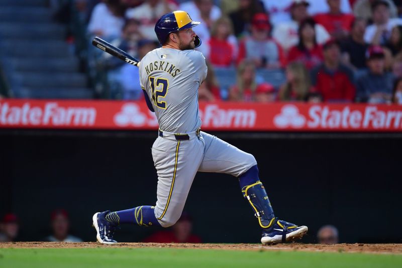 Jun 18, 2024; Anaheim, California, USA; Milwaukee Brewers first base Rhys Hoskins (12) hits a single against the Los Angeles Angels during the sixth inning at Angel Stadium. Mandatory Credit: Gary A. Vasquez-USA TODAY Sports