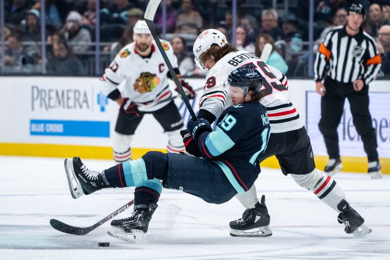 Nov 14, 2024; Seattle, Washington, USA;  Seattle Kraken forward Jared McCann (19) is knocked to the ice by Chicago Blackhawks forward Tyler Bertuzzi (59) during the first period at Climate Pledge Arena. Mandatory Credit: Stephen Brashear-Imagn Images