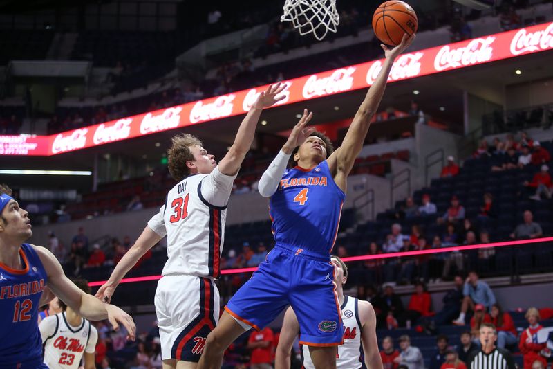 Feb 21, 2026; Oxford, Mississippi, USA; Florida Gators guard Alex Lloyd (4) shoots as Mississippi Rebels guard Zach Day (31) defends during the second half at The Sandy and John Black Pavilion at Ole Miss. Mandatory Credit: Petre Thomas-Imagn Images