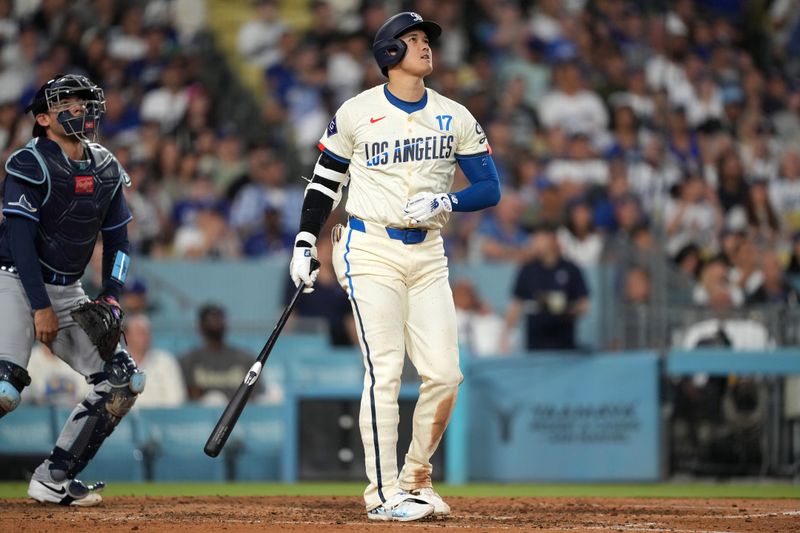 Aug 24, 2024; Los Angeles, California, USA; Los Angeles Dodgers designated hitter Shohei Ohtani (17) hits a two-run home run in the fifth inning as Tampa Bay Rays catcher Alex Jackson (28) watches at Dodger Stadium. Mandatory Credit: Kirby Lee-USA TODAY Sports