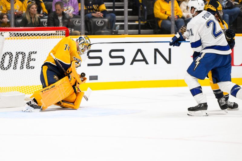 Nov 29, 2024; Nashville, Tennessee, USA;  Nashville Predators goaltender Juuse Saros (74) blocks the shot of Tampa Bay Lightning center Brayden Point (21) during the third period at Bridgestone Arena. Mandatory Credit: Steve Roberts-Imagn Images