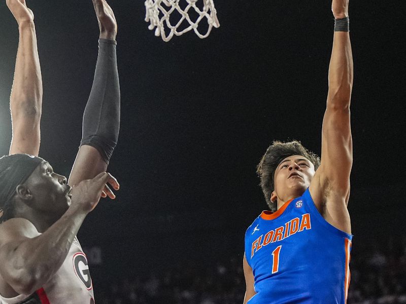 Feb 11, 2026; Athens, Georgia, USA; Florida Gators guard Xaivian Lee (1) scores a basket past Georgia Bulldogs center Somto Cyril (2) during the second half at Stegeman Coliseum. Mandatory Credit: Dale Zanine-Imagn Images