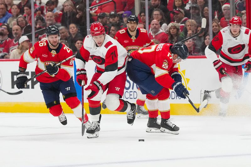 Dec 23, 2025; Raleigh, North Carolina, USA;  Florida Panthers center Evan Rodrigues (17) misses his check on Carolina Hurricanes left wing Taylor Hall (71) during the first period at Lenovo Center. Mandatory Credit: James Guillory-Imagn Images