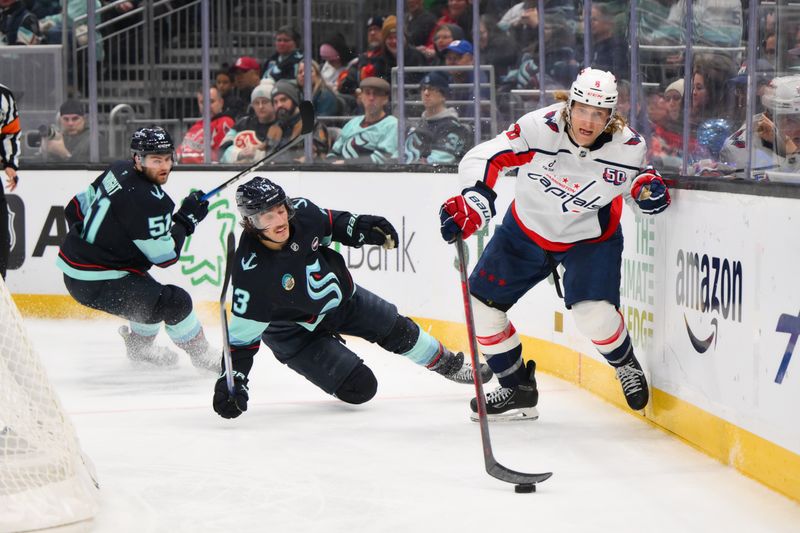 Jan 23, 2025; Seattle, Washington, USA; Washington Capitals defenseman Jakob Chychrun (6) plays the puck while Seattle Kraken left wing Brandon Tanev (13) falls down playing defense during the third period at Climate Pledge Arena. Mandatory Credit: Steven Bisig-Imagn Images