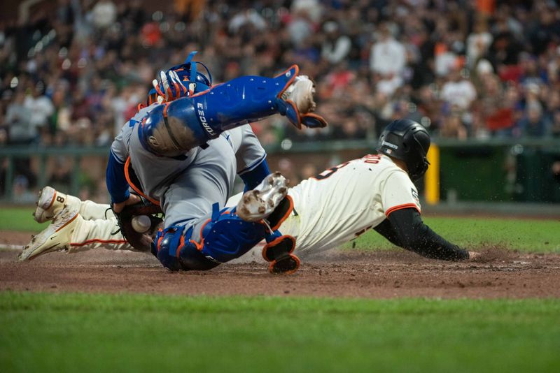 Apr 23, 2024; San Francisco, California, USA;  San Francisco Giants outfielder Michael Conforto (8) avoids the tag by New York Mets catcher Omar Narvaez (2) at home plate during the fifth inning at Oracle Park. Mandatory Credit: Ed Szczepanski-USA TODAY Sports