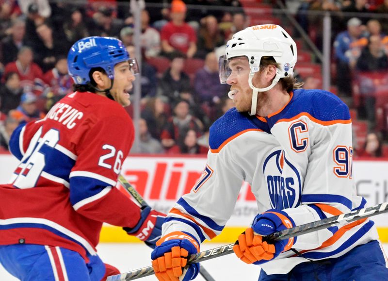 Jan 13, 2024; Montreal, Quebec, CAN; Montreal Canadiens defenseman Johnathan Kovacevic (26) and Edmonton Oilers forward Connor McDavid (97) going opposite directions during the first period at the Bell Centre. Mandatory Credit: Eric Bolte-USA TODAY Sports