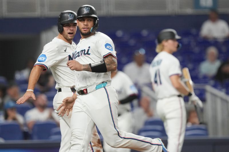 Aug 20, 2025; Miami, Florida, USA;  Miami Marlins catcher Agustin Ramírez, right and center fielder Jakob Marsee each score a run in the third inning against the St. Louis Cardinals at loanDepot Park. Mandatory Credit: Jim Rassol-Imagn Images