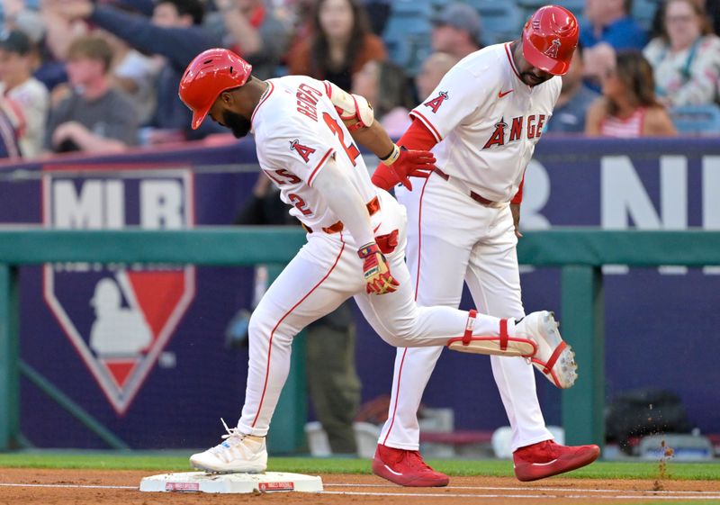 Apr 5, 2025; Anaheim, California, USA;  Los Angeles Angels third baseman Luis Rengifo (2) is congratulated by first base coach Bo Porter (88) as he rounds the bases a solo home run in the first inning against the Cleveland Guardians at Angel Stadium. Mandatory Credit: Jayne Kamin-Oncea-Imagn Images