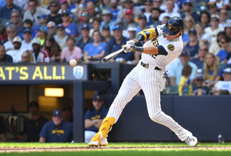 Jun 29, 2024; Milwaukee, Wisconsin, USA;Milwaukee Brewers outfielder Christian Yelich (22) hits a single against the Chicago Cubs in the eighth inning at American Family Field. Mandatory Credit: Michael McLoone-USA TODAY Sports